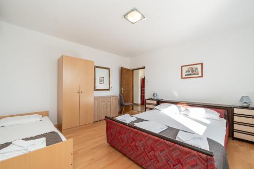 a large bedroom with two beds and a desk at Ema's Olive Garden Apt 1 with private parking, just 10 minutes drive from sandy beach in Poličnik