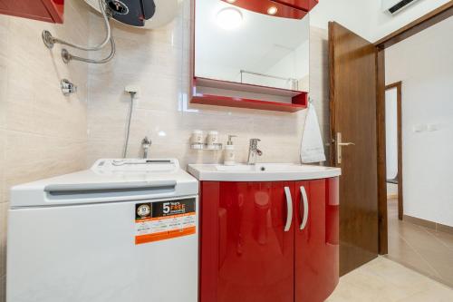 a bathroom with a sink and a red cabinet at Ema's Olive Garden Apt 1 with private parking, just 10 minutes drive from sandy beach in Poličnik