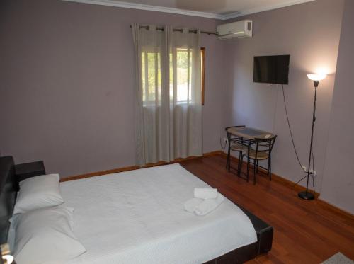 a bedroom with a bed and a table and a window at Quinta do Carvalho - Nature Guest Houses in Guimarães