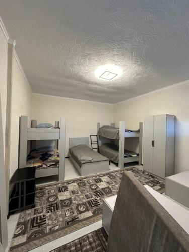 Chok-Tal的住宿－Береке，一间设有双层床的房间和一间铺有地毯的房间