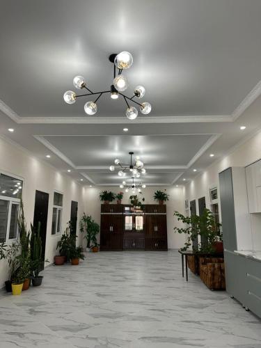 a lobby with a chandelier and plants in a building at Береке in Chok-Tal