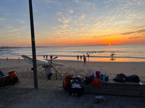 a group of people on a beach at sunset at Ocean View Private Cronulla Apartment in Cronulla