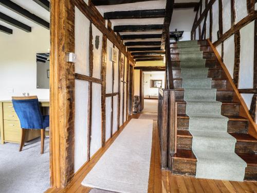 a staircase in a room with wooden beams at Pengwern in Pennant-Melangell