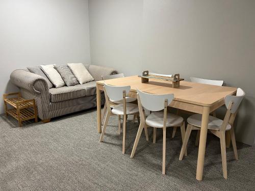 a living room with a table and chairs and a couch at Ocean View Private Cronulla Apartment in Cronulla