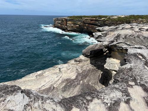 an aerial view of a rocky shore with the ocean at Ocean View Private Cronulla Apartment in Cronulla