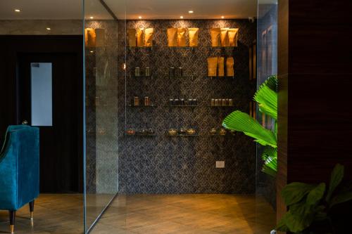a glass shower with a blue chair in a room at Viceroy Luxury Mountain Resort and Spa in Munnar