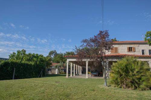 a house with a large yard with a palm tree at Quinta do Carvalho - Nature Guest Houses in Guimarães