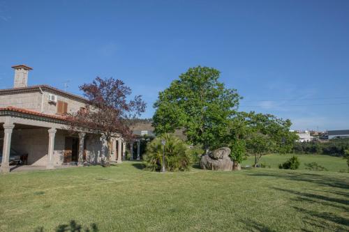 an old house with a statue in the yard at Quinta do Carvalho - Nature Guest Houses in Guimarães
