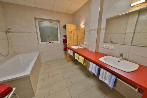 ein Badezimmer mit Waschbecken, Badewanne und Spiegel in der Unterkunft Barrierefreie 6 Personen Ferienwohnung im Landhausstil in Cochem