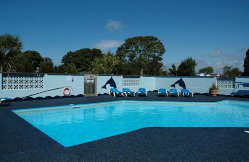 a swimming pool with chairs in front of a fence at Seagulls Rest in Newport