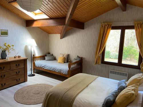 a bedroom with a bed and a dresser and a window at Les Oliviers in Sanguinet