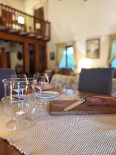 a wooden table with wine glasses on top of it at Les Oliviers in Sanguinet