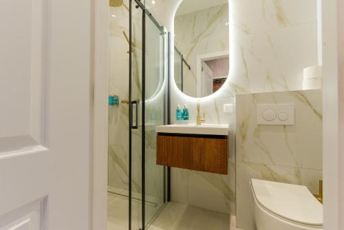 a bathroom with a shower and a toilet and a sink at Novallure Villa Margaretha - Short Stay Apartments in Rijswijk