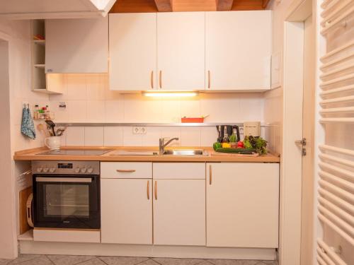 ノルデンにあるHoliday Home Schäfer by Interhomeの白いキャビネットとシンク付きのキッチン