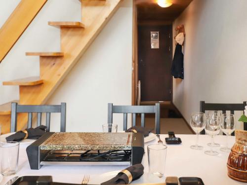 un comedor con una mesa con copas de vino en Apartment Les Arsets 301-11 by Interhome, en Arveyes