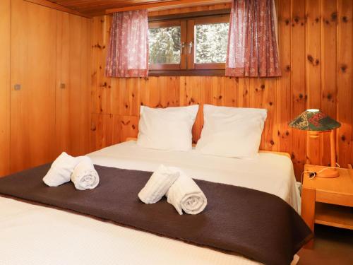Un dormitorio con una cama con toallas. en Apartment Les Arsets 301-11 by Interhome, en Arveyes