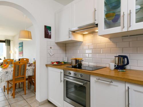 cocina con armarios blancos y fogones en Apartment Miralago - Utoring-43 by Interhome, en Piazzogna