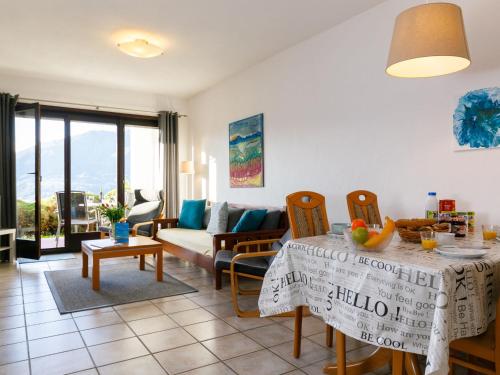 uma sala de estar com uma mesa e um sofá em Apartment Miralago - Utoring-43 by Interhome em Piazzogna