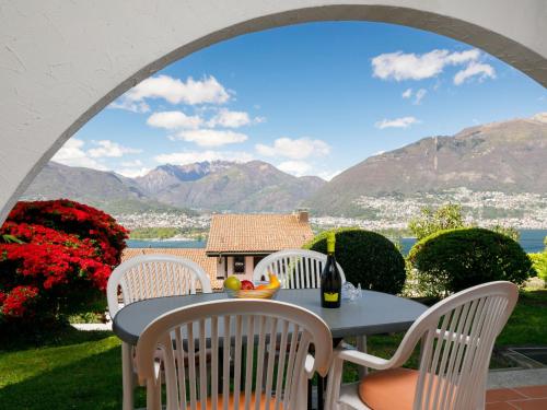 einen Tisch und Stühle auf einer Terrasse mit Bergblick in der Unterkunft Apartment Residence Miralago - Utoring Apt- A4 by Interhome in Piazzogna
