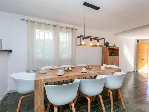 a dining room with a wooden table and white chairs at Villa Vilafortuny by Interhome in Vilafortuny