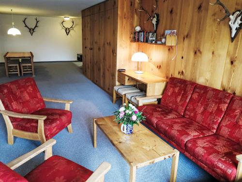 uma sala de estar com sofás vermelhos e uma mesa de centro em Apartment Utoring Acletta-120 by Interhome em Disentis
