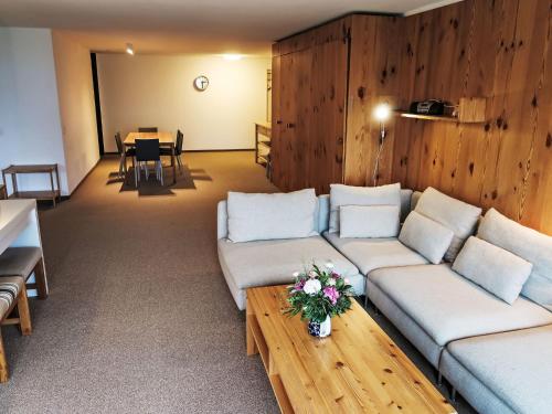 uma sala de estar com 2 sofás e uma mesa com uma sala de jantar em Apartment Apt B 022 by Interhome em Disentis