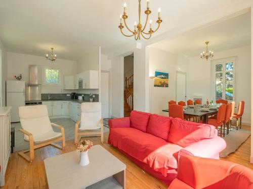 a living room with a red couch and a kitchen at Holiday Home Jeanne d'Arc-1 by Interhome in Saint-Palais-sur-Mer