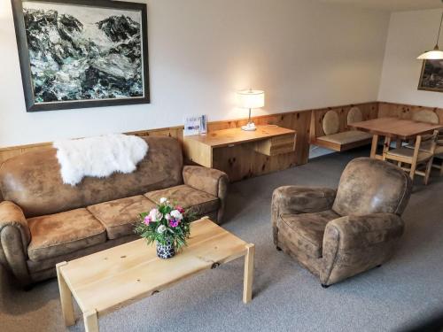 ein Wohnzimmer mit Sofas, Stühlen und einem Tisch in der Unterkunft Apartment Utoring Acletta-139 by Interhome in Disentis