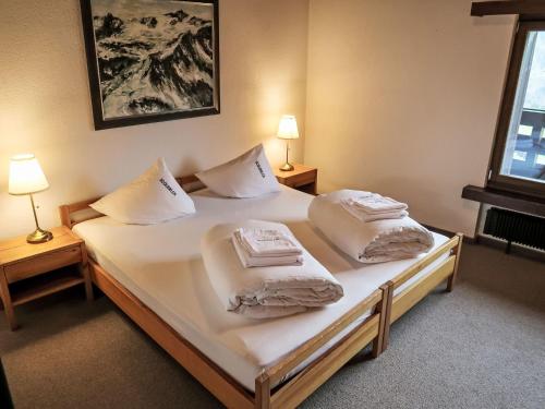 a bedroom with two beds with white sheets and pillows at Apartment Apt B 108 by Interhome in Disentis