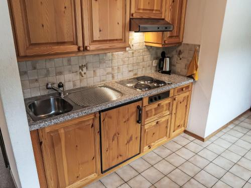 a kitchen with wooden cabinets and a sink at Apartment Apt B 108 by Interhome in Disentis