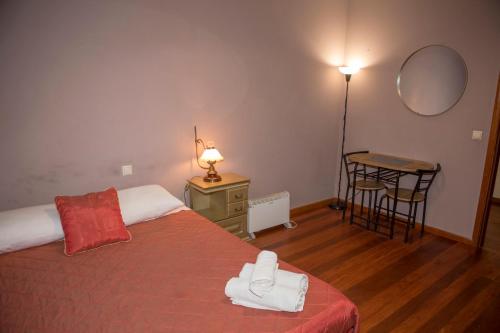 a bedroom with a bed and a table with a mirror at Quinta do Carvalho - Nature Guest Houses in Guimarães