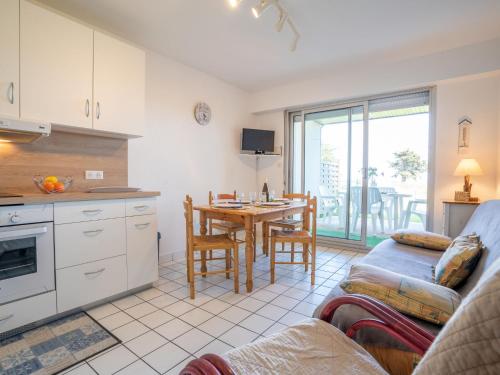 een keuken en een woonkamer met een tafel en een bank bij Apartment Domaine de la Greve by Interhome in Saint-Pierre-Quiberon