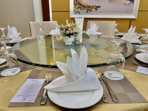 a glass table with a white plate on top of it at ST Vegas Hotel in Ban Nong-Heo