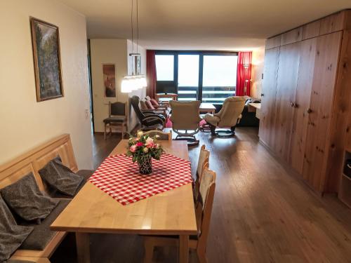 un soggiorno con tavolo e tovaglia rossa e bianca. di Apartment Utoring Acletta-132 by Interhome a Disentis