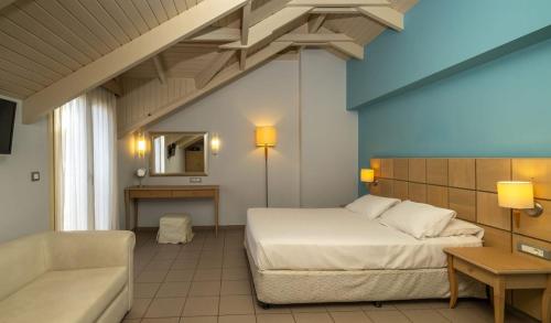 a bedroom with a bed and a couch in a room at Ionian Plaza Hotel & Spa in Argostoli
