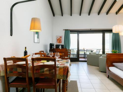 uma sala de jantar com uma mesa e algumas cadeiras em Apartment Miralago - Utoring-21 by Interhome em Piazzogna