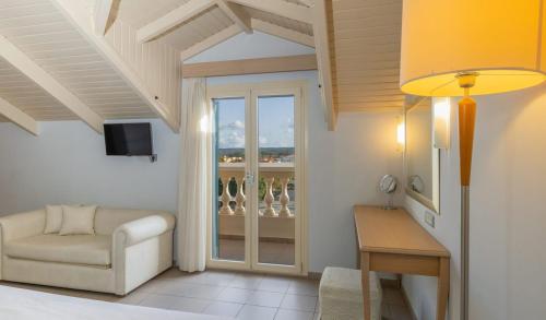 a living room with a couch and a chair and a window at Ionian Plaza Hotel & Spa in Argostoli