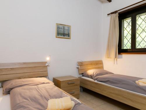 a bedroom with two beds and a window at Apartment Residence Miralago - Utoring Apt- A9 by Interhome in Piazzogna