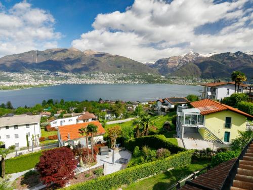 a town with a lake and mountains in the background at Apartment Residence Miralago - Utoring Apt- A9 by Interhome in Piazzogna
