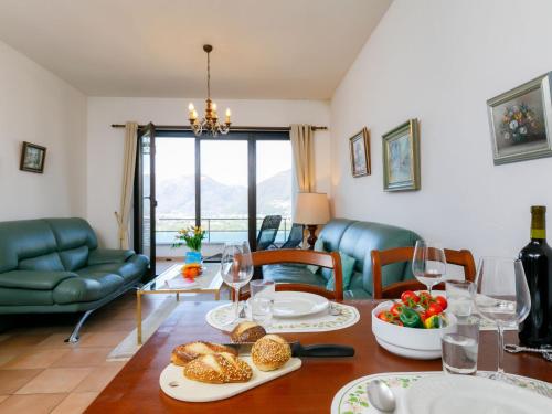 uma sala de estar com uma mesa com comida e copos de vinho em Apartment Residence Miralago - Utoring Apt- B16 by Interhome em Piazzogna