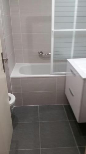 une salle de bain avec une baignoire blanche et des toilettes dans l'établissement La Baule Plage Benoît - Studio 25m, 4 personnes, Balcon, à La Baule