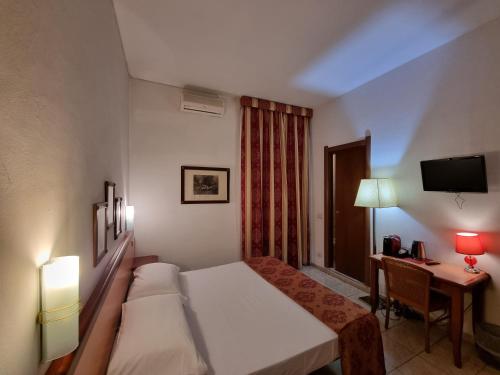 a hotel room with two beds and a desk and a television at Hotel Villa Luisa in Rapallo