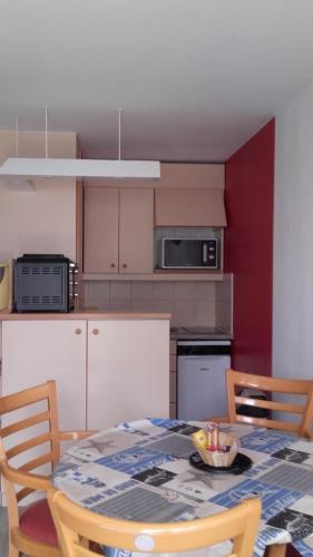 une cuisine avec une table et des chaises ainsi qu'une cuisine avec une table et une table dans l'établissement La Baule Plage Benoît - Studio 25m, 4 personnes, Balcon, à La Baule