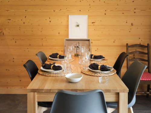 een houten tafel met borden en glazen erop bij Apartment Diamant 6 by Interhome in Villars-sur-Ollon