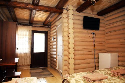 Cette chambre comprend un lit et une télévision murale. dans l'établissement Соляний Кристал, à Solotvyno
