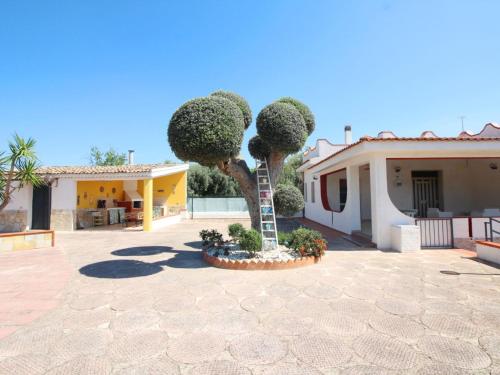 a palm tree in a courtyard next to a house at Villa Andrea by Interhome in Floridia