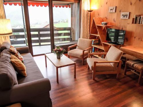 Una sala de estar con un sofá y sillas y un televisor. en Apartment Apt B 044 by Interhome, en Disentis