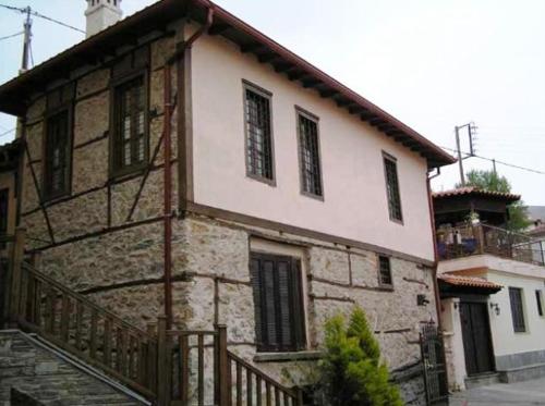 Casa de piedra antigua con porche y balcón en Siatistino Archontariki en Siatista