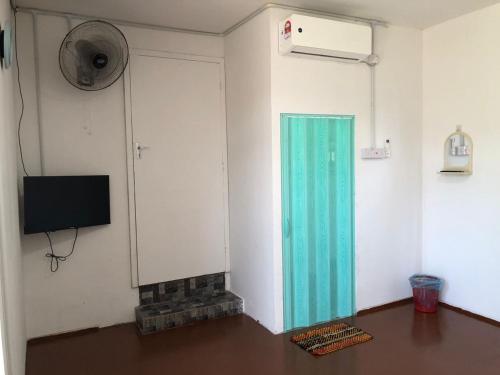 瓜拉丁加奴的住宿－Rest House Idaman BB Rumah tak kongsi，一间设有蓝色玻璃门和电视的房间