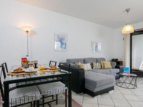 uma sala de estar com um sofá e uma mesa em Apartment Miralago - Utoring-24 by Interhome em Piazzogna